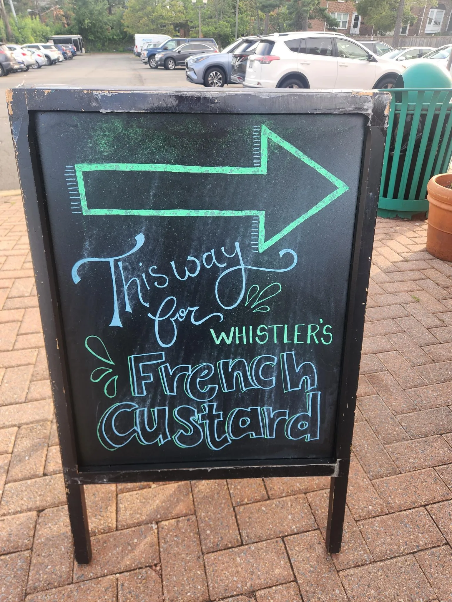 Sidewalk chalkboard with an arrow pointing toward Whistler's French custard