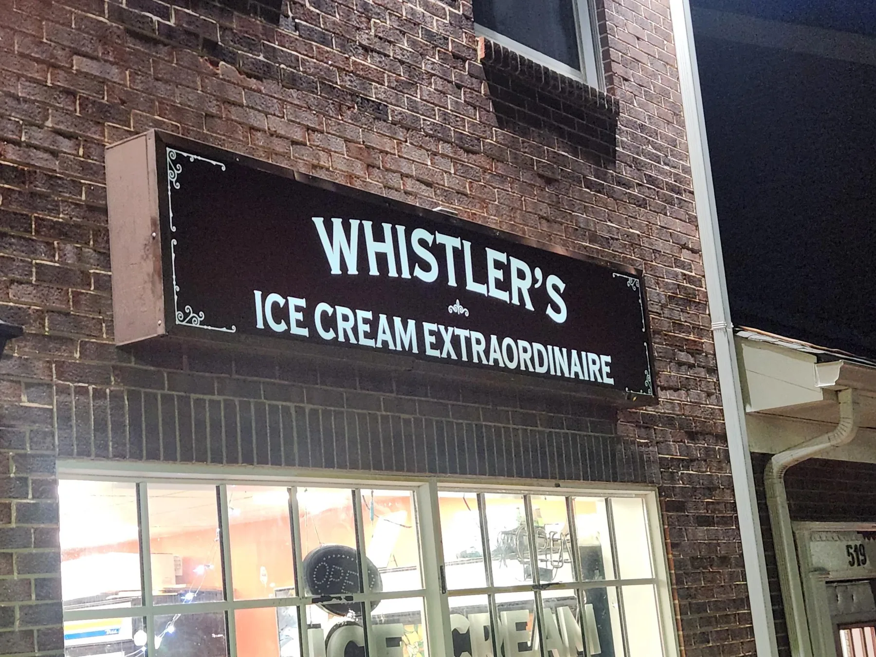 Whistler's Ice Cream Extraordinaire storefront sign at night