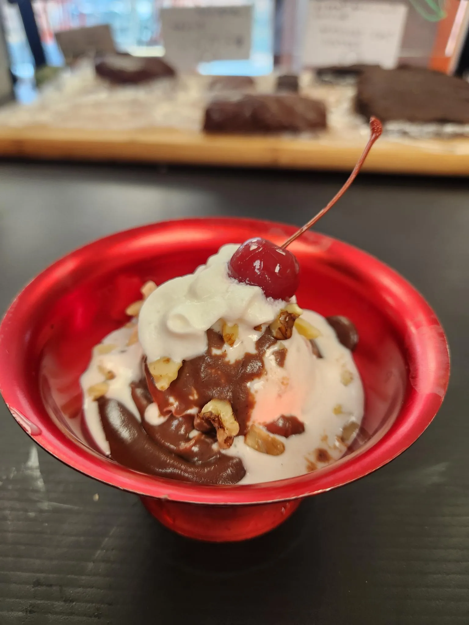 Chocolate sundae topped with nuts, whipped cream, and a cherry